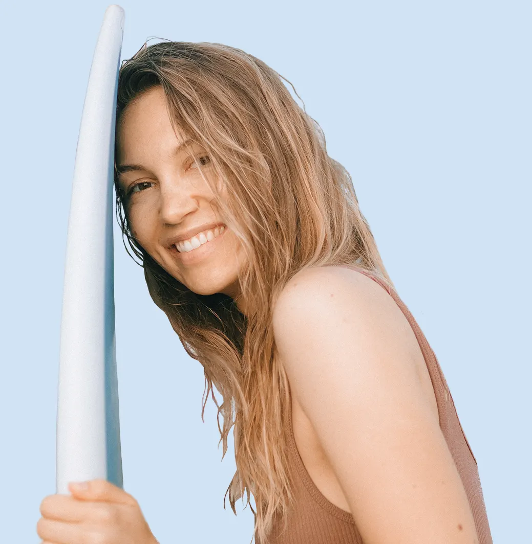Smiling surfer girl holding surfboard Smiling surfer girl holding surfboard