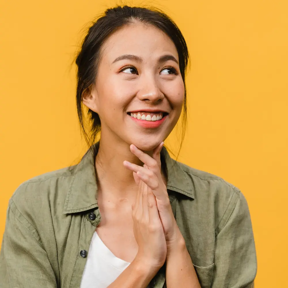 Young asian woman smiling with hands clasped Young asian woman smiling with hands clasped